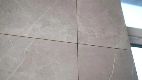 Close up video of a corner seam with grout on a marble effect ceramic tile wall Stock Photos