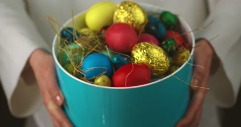 Close up video female celebrating Easter holding out vase full of painted eggs Stock Footage 150952623