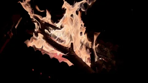 A close-up video of a fire. The fire is fanned and sparks fly. Stock Footage 320241702