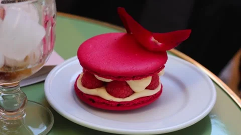 Close-up video footage of a filled raspberry macaron. Pink French pastry with Stock Footage 345683501