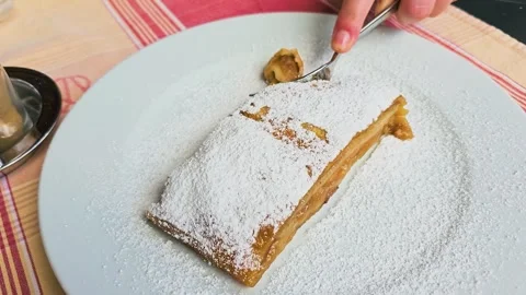 Close up video of a fork cutting a piece of apple strudel covered in powdered Stock Footage 336630667
