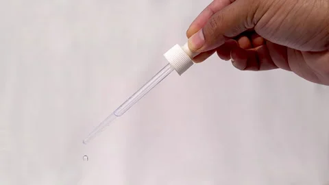 Close Up Video Of Hand Of A Man Using A Dropper Dripping Water From Dropper Stock Footage 267874774