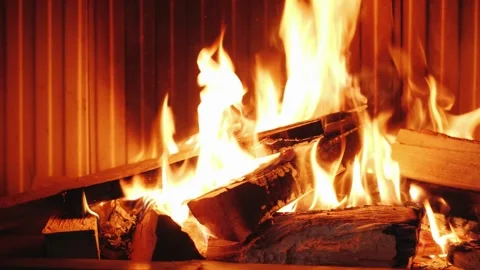 Close up video of hands adding firewood into a lit fireplace with crackling.. Stock Footage 335059778