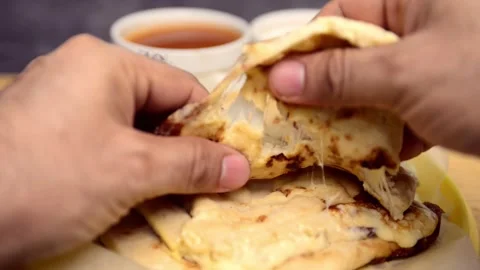 Close-up video of hands cutting open pupusas, revealing melted cheese stran.. Stock-Footage 279626516