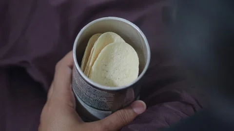 Close up video of hands picking up delicious potato chips from a cylindrica.. Stock Footage 331725914