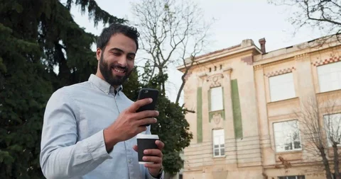 Close up Video of Handsome Bearded Man walking in the City while texting Видео 123401295