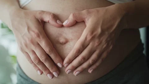 Close up video of heart made of  hands on abdomen Stock Footage 132173580