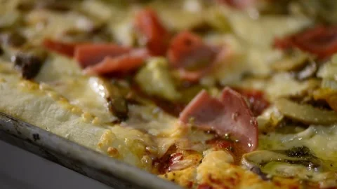 A close-up video of a homemade rectangular pizza topped with ham, artichoke.. Stock-Footage 302236515