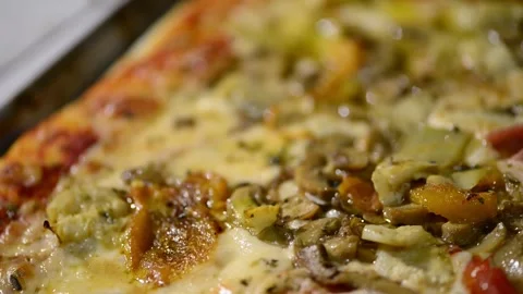 A close-up video of a homemade rectangular pizza topped with ham, artichoke.. 動画素材 302236516