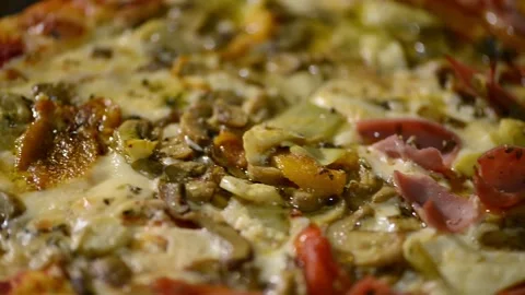 A close-up video of a homemade rectangular pizza topped with ham, artichoke.. 動画素材 302236533