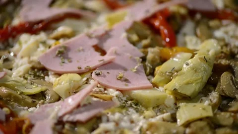 A close-up video of a homemade rectangular pizza topped with ham, artichoke.. 動画素材 302236546