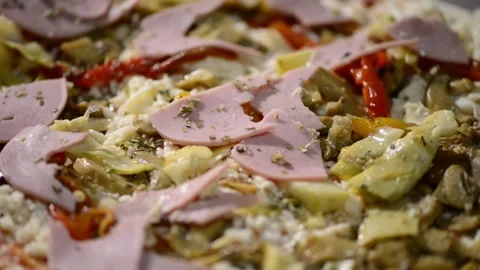 A close-up video of a homemade rectangular pizza topped with ham, artichoke.. 動画素材 302236567