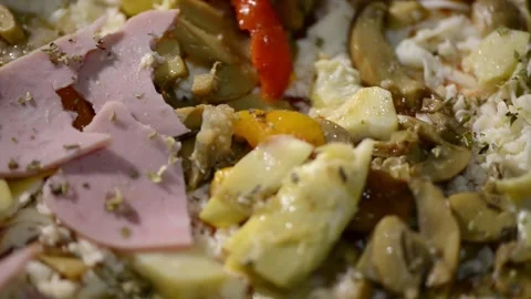A close-up video of a homemade rectangular pizza topped with ham, artichoke.. 動画素材 302236568