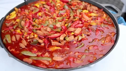 A close-up video of a large pan filled with colorful peppers and sliced sausages Video stock 303286347