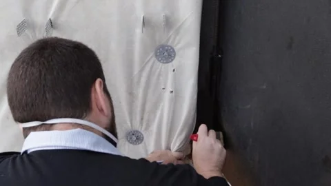 Close-up video of a man applying fresh black paint along the edge of an old.. Video stock 345412418