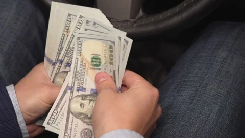 Close up video of man counting dollar banknotes sitting in car, money Stock Footage 304578734
