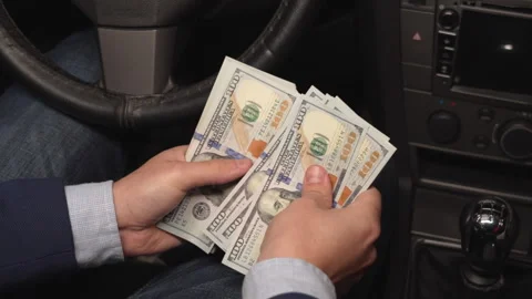Close up video of man counting dollar banknotes sitting in car, money Stock Footage 313505714