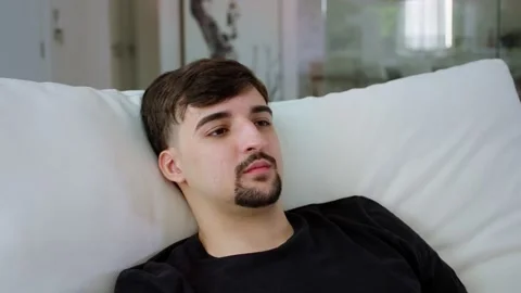 Close-up video of man relaxing on a couch indoor in the morning. Stock Footage 247660802