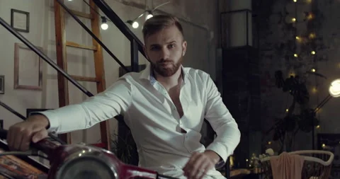 A close up video of a man sitting on his motorcycle in his garage. Stock Footage 135113407