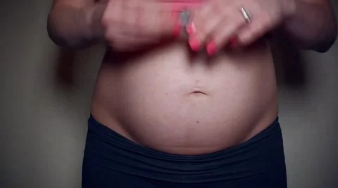 Close up Video of Mother using lipstick to draw a Heart on Her Pregnant Belly Stock Footage 49389927