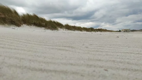 Close-up video of a moving sand during windy weather on German coast of Balti Stock Footage 131180031