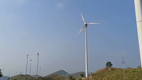 Close up Video of Multiple Windmills functioning on top of hill on a sunny day Stock Footage 164304716
