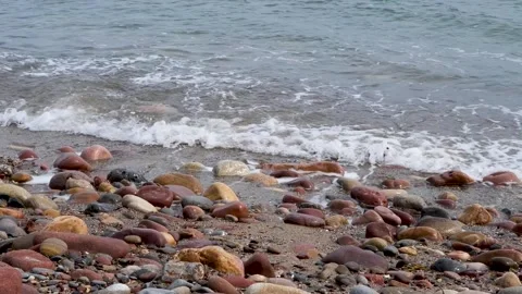Close-up video of ocean waves softly caressing seaside stones Stock Footage 321475869