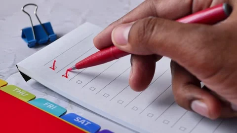Close up video of person hand making red check marks on a white to do list pa Stock Footage 332745677
