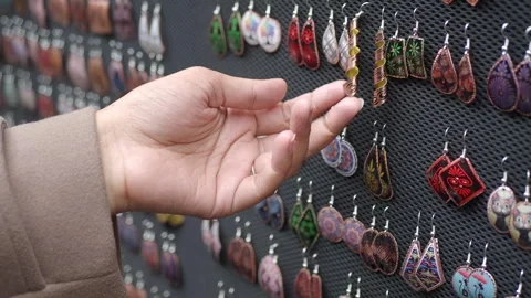 A close up video of a person's hand browsing through an array of handmade e.. Video stock 333153275