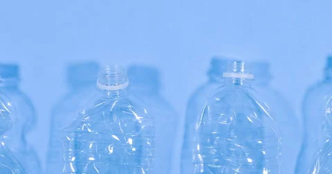 Close up video of plastic bottles isolated on blue background. Recycle waste Stock Footage 268442059