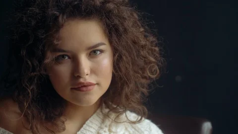 Close up video portrait of young beutiful cute curly girl posing on dark Stock Footage 101503867