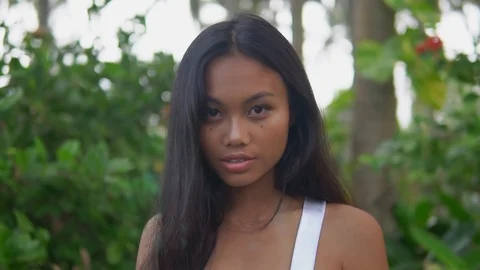 Close up video pretty young brunette female with healthy dark skin looks at cam Stock Footage 108770436