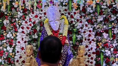 A close-up video of a priest performing puja or aarti to the Sai Baba or Sa.. Video stock 328011491