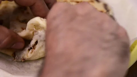 Close-up video of pupusas being cut open by hand, revealing strands of deli.. 動画素材 277789509