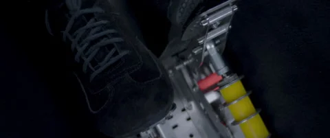 Close-up video of a race car drivers legs and feet engaging the pedals Stock Footage 318921609