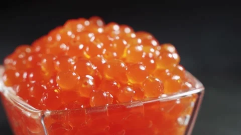 Close-up video of red caviar on black background Stock Footage 148456731