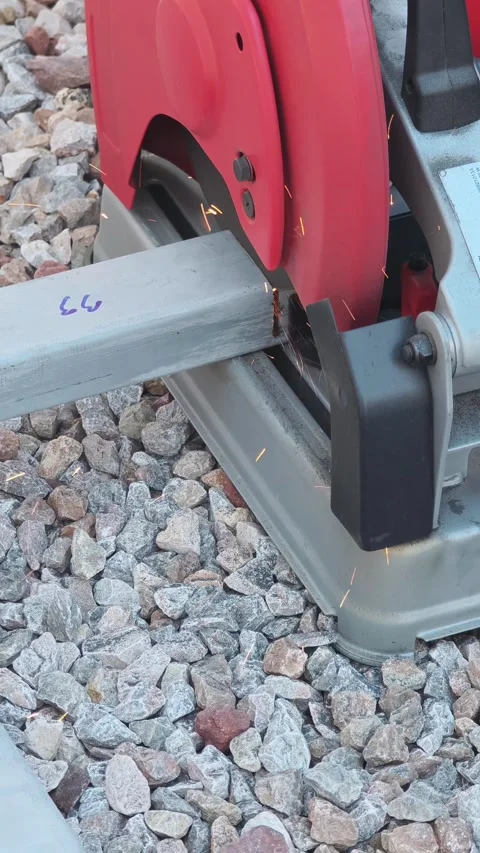 Close up video of red electric chop saw machine cutting square steel pipe . Video stock 338175321