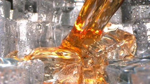 Close up video of refreshing golden whiskey being poured over many glistening Stock Footage 340951432