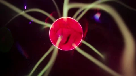 Close up video of a rotating red plasma ball emitting glowing electrical. Stock Footage 345289700