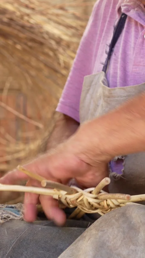 Close up video shot of old man hands working on wicker art craft Stock Footage 285425313
