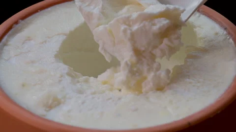 Close-up video showing a spoon scooping yogurt from a clay pot. Stock Footage 280831439