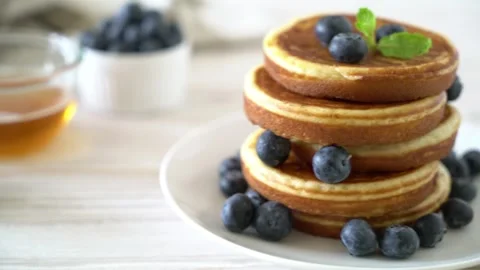 A close up video of stack of homemade pancakes with fresh blueberries on wh.. Stock Footage 337604229