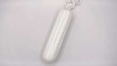 A close-up video of a tampon rotating on a white platform Stock Footage 289775556