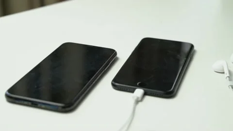 Close up video of two black smartphone and white earphone Video stock 163863142