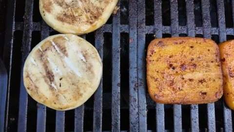 Close-up video of two different types of cheese grilling on barbecue grate Stock Footage 335220127