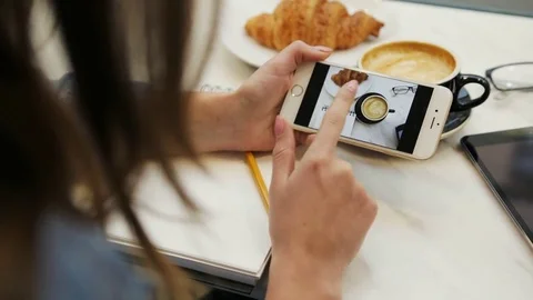 Close-up video of two women looking photo on smartphone in the cafe. Choosing Stock Footage 72361962