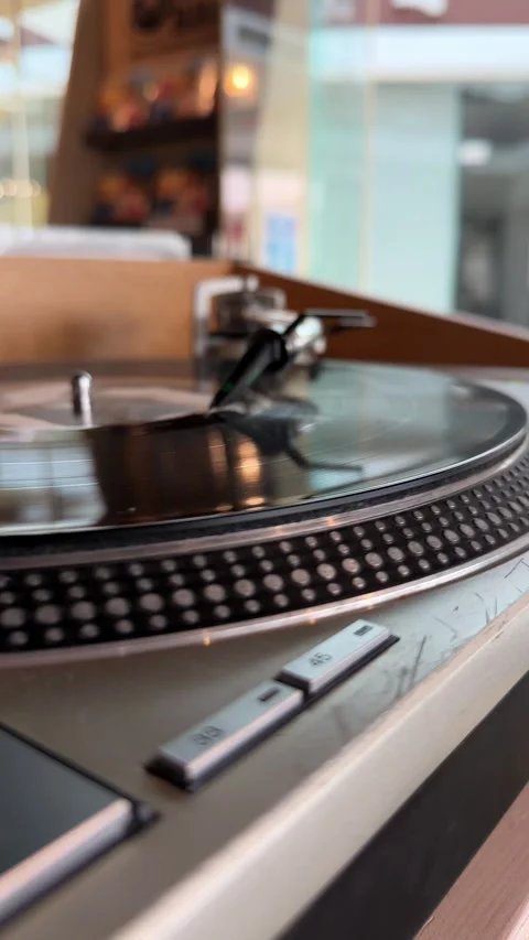 Close-up video of a vinyl record spinning on a turntable in a cafe, illustrating Vidéo 346692226