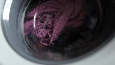 Close up video of washing machine, washes dirty colorful clothes. Stock Footage 238538023