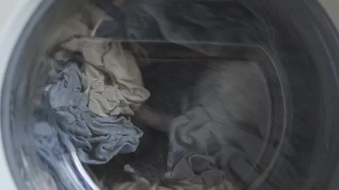 Close up video of washing machine. White washing machine washes dirty clothes. Stock Footage 241022893