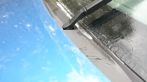 Close-up video of windshield washer jets spraying cleaning fluid onto a car Stock Footage 323250273